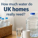 Wicker basket of bottled water and a large water container on a kitchen table in a bright UK home, with a mug and glass.